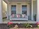 Inviting front porch swing adorned with decorative pillows, set against a backdrop of stylish windows and lush greenery at 2889 Backman St, Mount Pleasant, SC 29466
