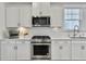 Well-lit kitchen with stainless steel appliances, white cabinets, and modern countertops at 2889 Backman St, Mount Pleasant, SC 29466