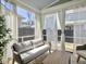 Bright sunroom featuring a wicker couch, white curtains, and a wooden table, ideal for relaxation at 2889 Backman St, Mount Pleasant, SC 29466