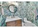 Powder room featuring designer wallpaper, modern fixtures, and a circular mirror at 2906 Quarterdeck Ct, Mount Pleasant, SC 29466