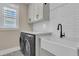 Bright laundry room featuring new washer and dryer, sink, and subway tile backsplash at 2906 Quarterdeck Ct, Mount Pleasant, SC 29466