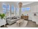 This living room offers tons of natural light, with a decorative chandelier and modern furniture at 2906 Quarterdeck Ct, Mount Pleasant, SC 29466