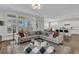 Bright and open living space with large windows, a sectional sofa, and seamless flow into the modern kitchen at 2906 Quarterdeck Ct, Mount Pleasant, SC 29466