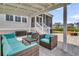 Inviting covered patio with wicker furniture, turquoise cushions, and access to a screened porch at 2906 Quarterdeck Ct, Mount Pleasant, SC 29466