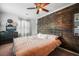 Cozy bedroom features a wooden accent wall, ceiling fan, and a comfortable bed at 310 Land O Pines Cir, Moncks Corner, SC 29461