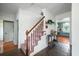 Welcoming entryway featuring a staircase, decor accents and a glimpse of the kitchen and other rooms at 310 Land O Pines Cir, Moncks Corner, SC 29461
