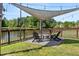 Inviting backyard deck with a fire pit, shade covering, and a view of the tranquil lake, perfect for outdoor entertaining at 3133 Cold Harbor Way, Charleston, SC 29414