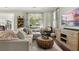 Inviting living room with a stylish sectional, hardwood floors, and a view of the outdoor greenery through large windows at 3133 Cold Harbor Way, Charleston, SC 29414
