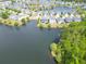 Aerial image of a lakeside community featuring waterfront properties, tree lined street and lush vegetation at 3149 Timberline Dr, Johns Island, SC 29455
