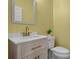 Stylish powder room with wooden vanity, modern gold faucet, and green-yellow walls at 3149 Timberline Dr, Johns Island, SC 29455