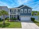 Beautiful two-story blue house has a porch on the second level and a well maintained lawn with an attached two-car garage at 3149 Timberline Dr, Johns Island, SC 29455