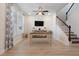 Bright, well-lit living room with light wood floors, wood desk, ceiling fan, and decorated with plants at 3149 Timberline Dr, Johns Island, SC 29455