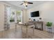 Bright, well-lit living room with light wood floors, wood desk, ceiling fan, and decorated with plants at 3149 Timberline Dr, Johns Island, SC 29455