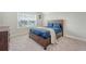 Carpeted bedroom has a dark wood bed frame, soft blanket, and sunny window at 317 Fiddleback Dr, Summerville, SC 29486