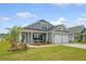 Inviting curb appeal with gray siding, stone accents, and a cozy front porch with rocking chairs at 317 Fiddleback Dr, Summerville, SC 29486