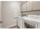 Efficient laundry room features modern washer and dryer, with overhead cabinets at 317 Fiddleback Dr, Summerville, SC 29486