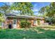 Brick home backyard featuring a well-maintained lawn, mature trees, and a cozy patio area at 32 Heathwood Dr, Charleston, SC 29407