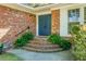 Charming front entrance with brick steps, a blue front door, and landscaped greenery at 32 Heathwood Dr, Charleston, SC 29407