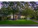 Charming brick home featuring a lush green lawn, mature trees, and a welcoming entrance at 32 Heathwood Dr, Charleston, SC 29407