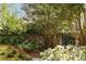 Beautiful backyard garden featuring brick wall, wrought iron fence, mature trees and blooming white azaleas at 333 W Confederate Cir, Charleston, SC 29407