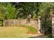 Private backyard with brick wall, iron gate, lush green lawn and mature landscaping at 333 W Confederate Cir, Charleston, SC 29407