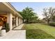 Expansive backyard featuring a lush lawn, mature trees, and a stone patio with access to the home through sliding glass doors at 333 W Confederate Cir, Charleston, SC 29407