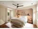 A well-lit bedroom boasts a unique arched headboard with sconces, a ceiling fan, and an exterior door with sidelight at 333 W Confederate Cir, Charleston, SC 29407