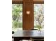 Bright dining area with wood-paneled accent wall, sconce, and large window overlooking lush landscape at 333 W Confederate Cir, Charleston, SC 29407