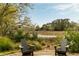 Picturesque backyard setting with a firepit and Adirondack chairs, overlooking the water and lush greenery at 333 W Confederate Cir, Charleston, SC 29407