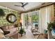 Stylish living room with tropical wallpaper, cozy furniture, and an inviting view of the pool and patio beyond at 333 W Confederate Cir, Charleston, SC 29407