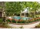 Beautiful pool surrounded by lush landscaping and flowers with a covered area for relaxation and a brick surround at 333 W Confederate Cir, Charleston, SC 29407