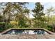 A cozy splash pool surrounded by greenery and trees, inviting relaxation and serenity, with lounge chairs placed nearby at 333 W Confederate Cir, Charleston, SC 29407
