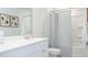 Bright bathroom features a white vanity, framed mirror, framed art and a tub with a stylish striped curtain at 339 Pine Crest View Dr, Summerville, SC 29486