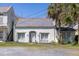 Charming white house with a slate roof, complemented by palm trees, and a small front yard with chairs at 34 Smith St, Charleston, SC 29401