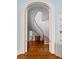 Elegant winding staircase with hardwood floors and white trim, viewed through an arched doorway at 34 Smith St, Charleston, SC 29401
