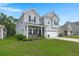 Charming two-story home with lush front lawn and a covered front porch invites you to relaxed suburban living at 3438 Great Egret Dr, Johns Island, SC 29455
