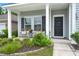 Inviting front porch with seating area, landscaping, and a black door with a wreath at 3438 Great Egret Dr, Johns Island, SC 29455