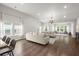 Spacious living room filled with natural light features hardwood floors and a modern chandelier at 3438 Great Egret Dr, Johns Island, SC 29455