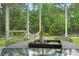 Enjoy the screened porch with a table set for wine and glasses with a view of the backyard at 3438 Great Egret Dr, Johns Island, SC 29455