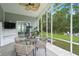 Relax on the screened porch with a ceiling fan, table, and view of the landscaped backyard at 3438 Great Egret Dr, Johns Island, SC 29455