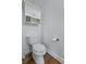 A half bathroom with toilet, base trim, and wall cabinet for storage with decorative knobs at 4020 Conant Rd, Mount Pleasant, SC 29466