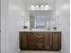Well-lit bathroom vanity area featuring dual sinks, wooden cabinetry, and a large mirror at 4020 Conant Rd, Mount Pleasant, SC 29466