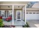 Cozy covered porch with red wicker chairs, complementing the home's facade and inviting entrance at 403 Fox Sparrow Ct, Summerville, SC 29486