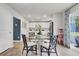 Open concept dining area with a glass table and view into a modern, white kitchen at 4115 Rising Tide Dr, Summerville, SC 29485
