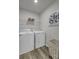 Modern laundry room with front-load washer and dryer, wire shelving, and stylish decor at 4115 Rising Tide Dr, Summerville, SC 29485