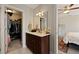 Bathroom with dark wood vanity, large mirror, and access to a walk-in closet and primary bedroom at 4143 Rigsby Ln, Charleston, SC 29414