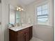 Bathroom vanity featuring a white countertop, dark wood cabinets and a window providing natural light at 4143 Rigsby Ln, Charleston, SC 29414