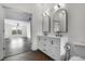 Bright bathroom with double vanity, tiled floor, and an open doorway to an adjacent room at 4735 Arco Ln, North Charleston, SC 29418
