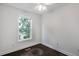 Bedroom with a window that lets in plenty of natural light, complemented by dark hardwood floors and white walls at 4735 Arco Ln, North Charleston, SC 29418