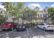 View of townhouses with assigned parking spaces in front and mature trees providing pleasant shade at 4735 Arco Ln, North Charleston, SC 29418